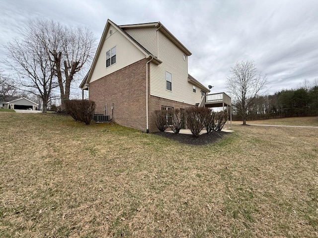 view of property exterior featuring a yard, brick siding, and central AC unit