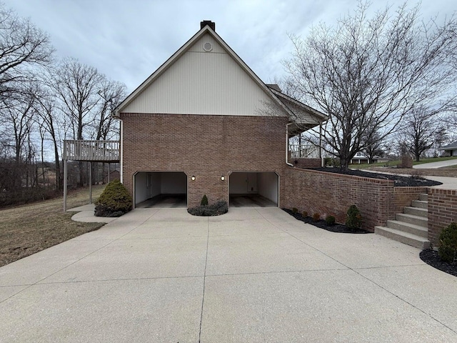 view of side of home featuring brick siding, concrete driveway, and an attached garage