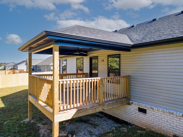 rear view of property featuring ceiling fan, a deck, and a lawn