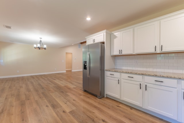 kitchen with light wood-type flooring, a notable chandelier, white cabinetry, and stainless steel refrigerator with ice dispenser