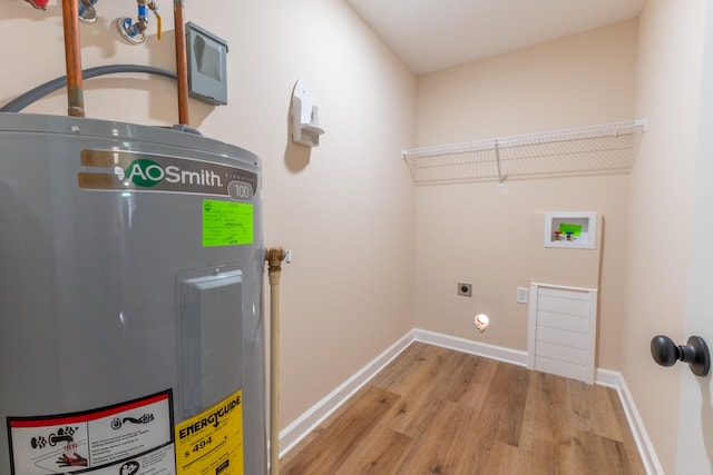 washroom featuring light hardwood / wood-style flooring, hookup for an electric dryer, hookup for a washing machine, and electric water heater