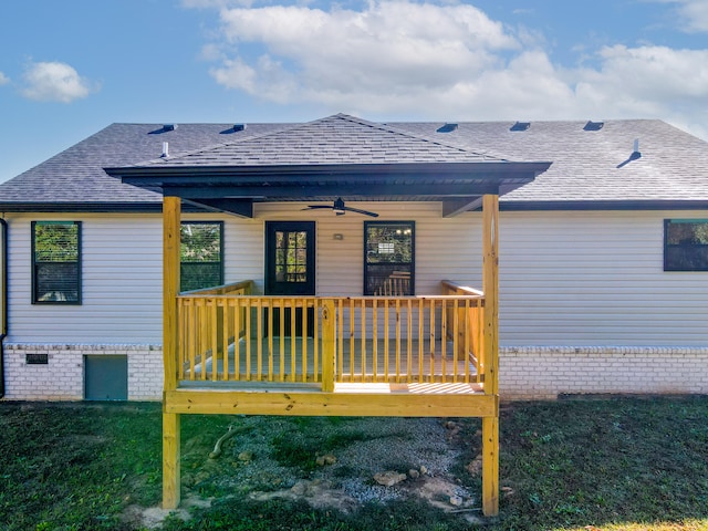 back of house featuring ceiling fan, a wooden deck, and a yard