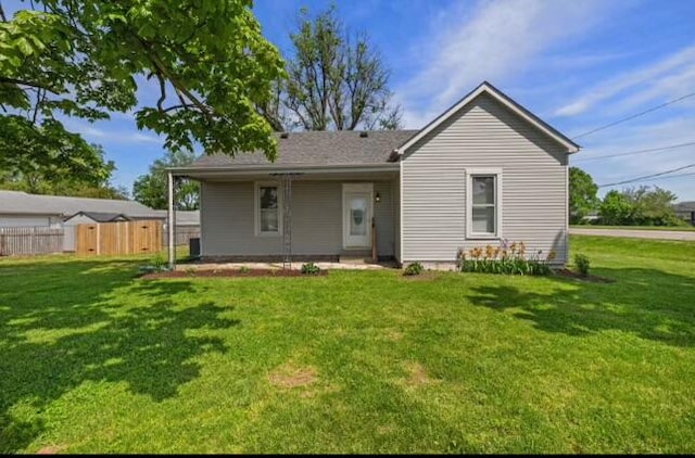 rear view of property featuring a lawn