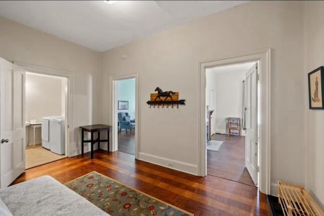 corridor with separate washer and dryer and dark hardwood / wood-style flooring