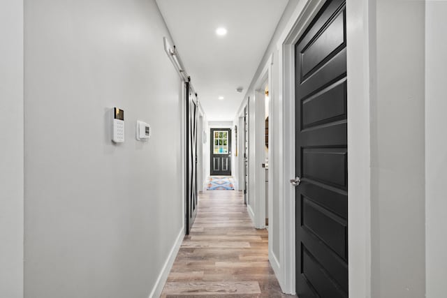 hall featuring light hardwood / wood-style flooring and a barn door