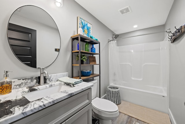 full bathroom featuring hardwood / wood-style flooring, vanity, shower / bath combo with shower curtain, and toilet