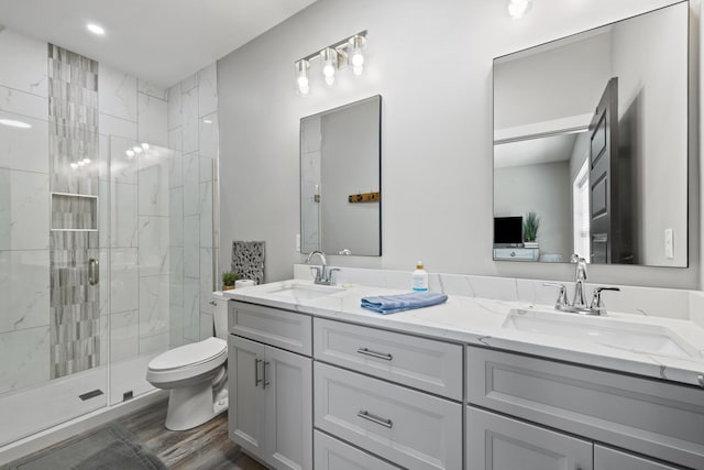 bathroom with vanity, toilet, a shower with door, and hardwood / wood-style flooring