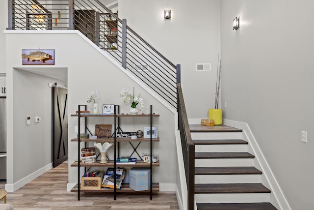 staircase featuring hardwood / wood-style floors and a barn door