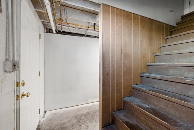 stairs with wooden walls and concrete flooring