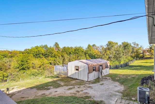 view of outbuilding featuring cooling unit and a yard