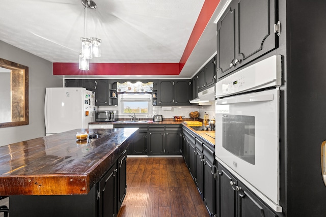 kitchen with dark hardwood / wood-style floors, butcher block counters, sink, and white appliances