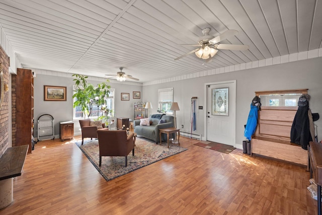 living room with a healthy amount of sunlight, ceiling fan, wood-type flooring, and baseboard heating