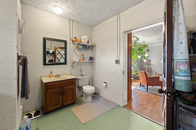 bathroom with concrete flooring, vanity, and toilet