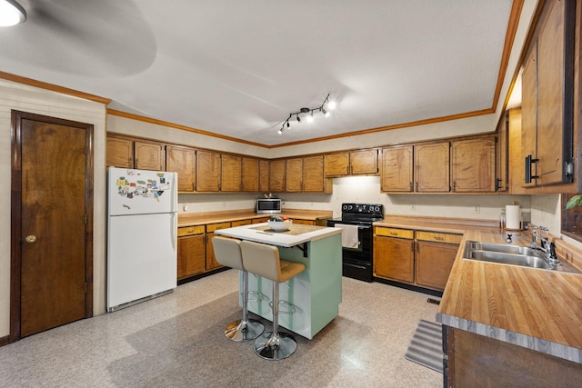 kitchen with a breakfast bar area, a kitchen island, electric range, sink, and white fridge