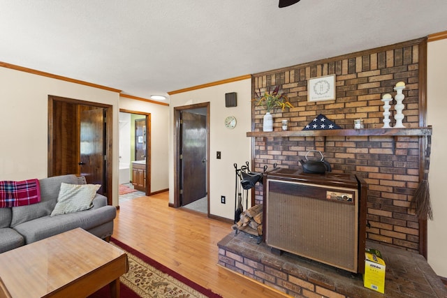 living room with crown molding, light wood-type flooring, and a textured ceiling