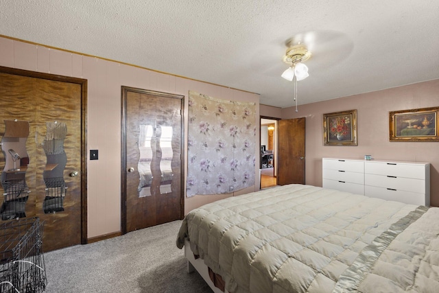 bedroom with a textured ceiling, ceiling fan, and carpet flooring