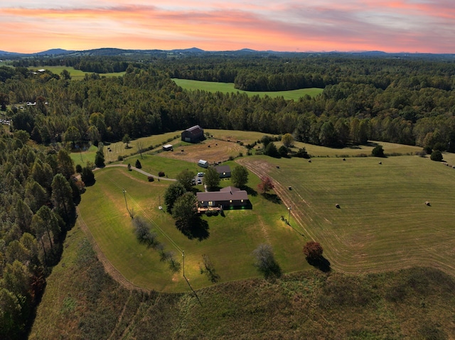 aerial view at dusk featuring a mountain view and a rural view