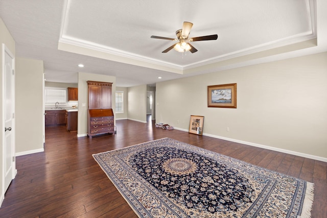 interior space featuring ceiling fan, dark hardwood / wood-style floors, a raised ceiling, and sink