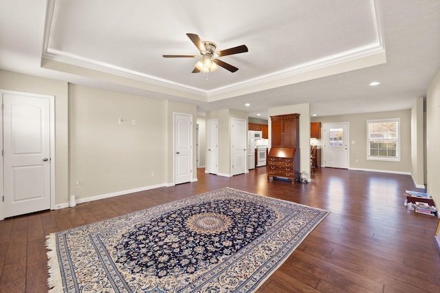 living room featuring a textured ceiling, dark hardwood / wood-style floors, ceiling fan, and a tray ceiling