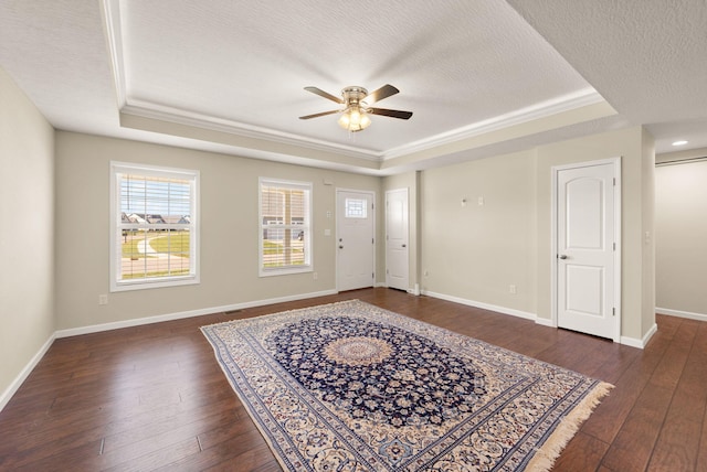 entryway with dark wood-type flooring, a textured ceiling, and a tray ceiling