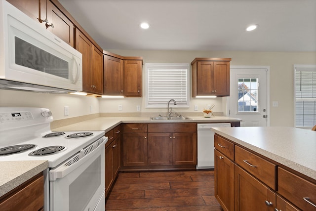 kitchen with dark hardwood / wood-style flooring, white appliances, and sink