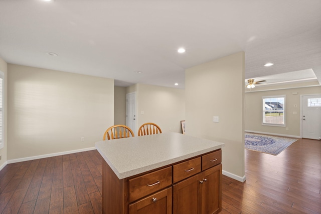 kitchen featuring dark hardwood / wood-style floors, a center island, and ceiling fan