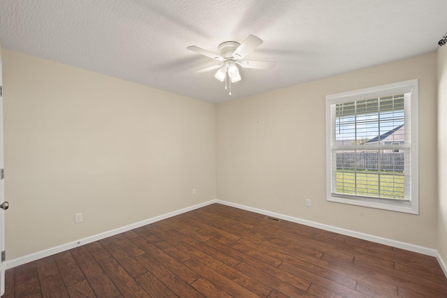 spare room featuring dark hardwood / wood-style flooring, a textured ceiling, and ceiling fan