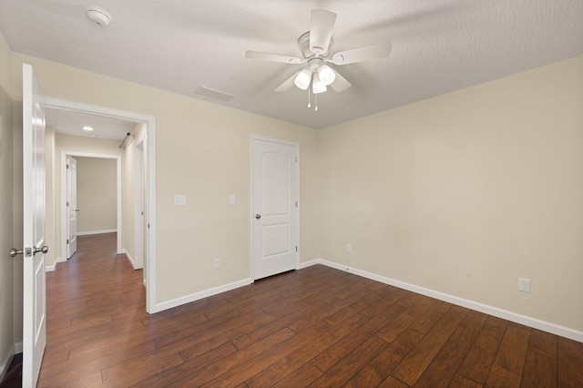 unfurnished bedroom with ceiling fan, a textured ceiling, and dark hardwood / wood-style flooring