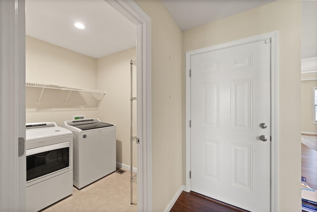 laundry room with wood-type flooring and washer and clothes dryer