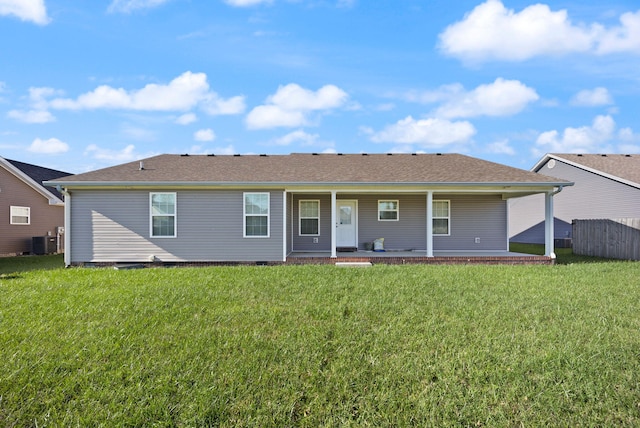 rear view of house featuring central AC unit and a yard