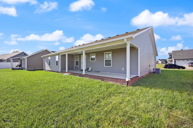 back of house with central AC unit, a lawn, and a patio area