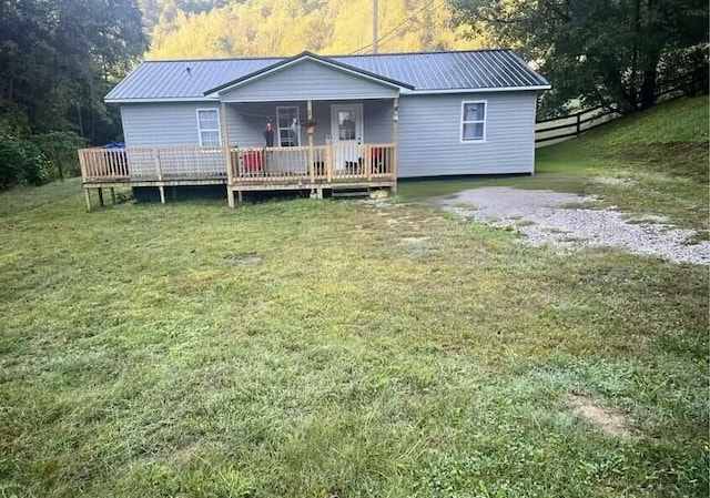 back of property featuring a wooden deck and a lawn