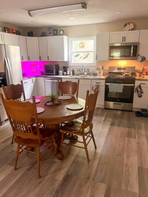 kitchen with light wood-type flooring, white cabinetry, sink, and stainless steel appliances