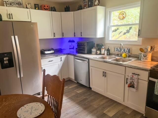 kitchen featuring stainless steel appliances, light hardwood / wood-style flooring, sink, and white cabinetry