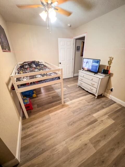 bedroom with ceiling fan and wood-type flooring