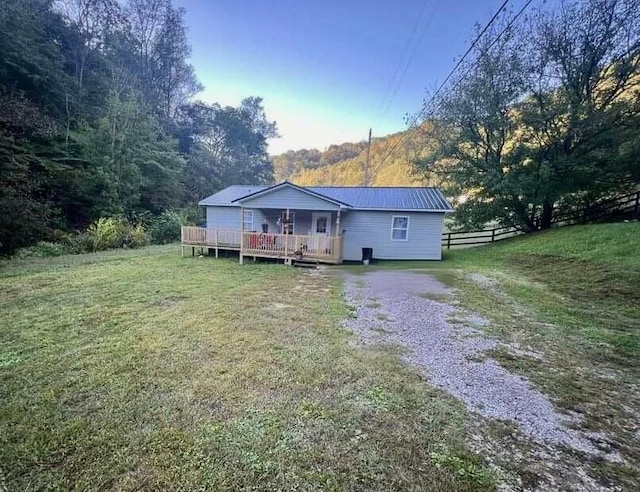 rear view of house featuring a yard and a wooden deck