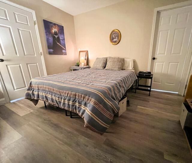 bedroom with dark hardwood / wood-style flooring