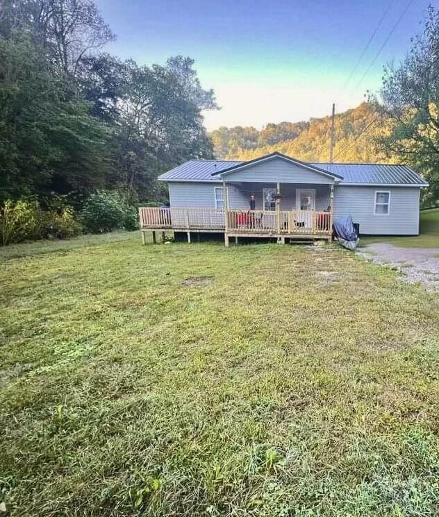 back of house with a lawn and a deck