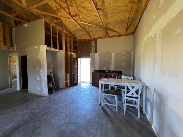 miscellaneous room with concrete floors and high vaulted ceiling