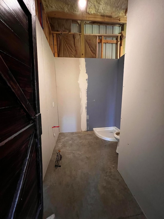 bathroom featuring toilet and concrete flooring