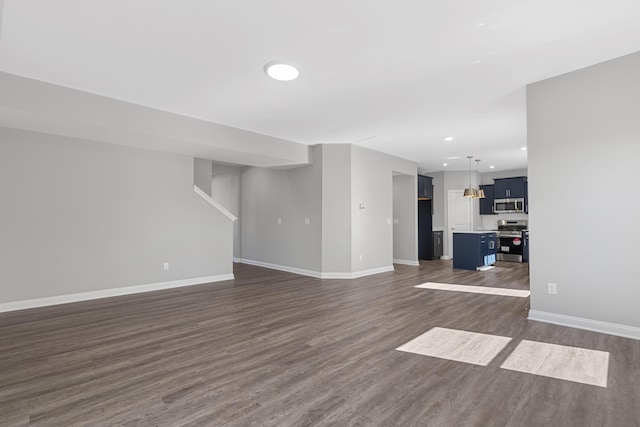 unfurnished living room with baseboards, dark wood-type flooring, and recessed lighting