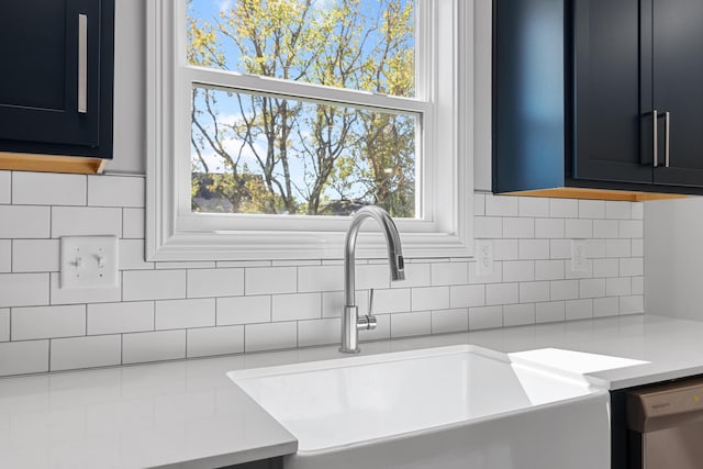 interior details with dishwasher, backsplash, light countertops, and a sink