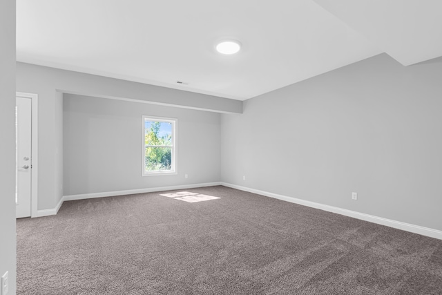 spare room featuring carpet floors, visible vents, and baseboards