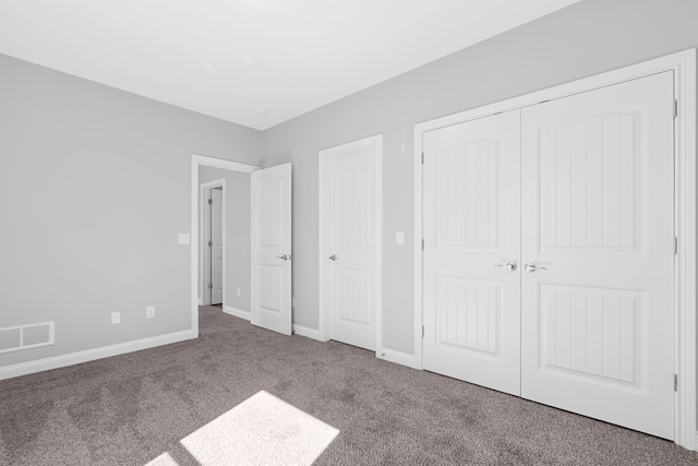 unfurnished bedroom featuring carpet, a closet, visible vents, and baseboards