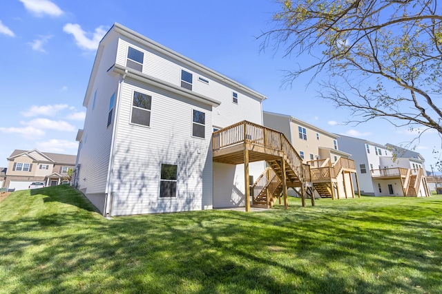 rear view of property featuring a residential view, a yard, a wooden deck, and stairs