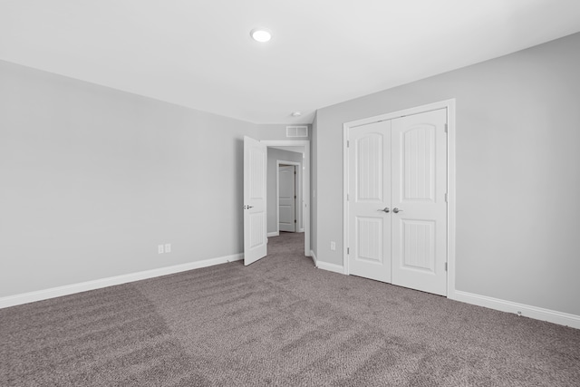 unfurnished bedroom with carpet, a closet, visible vents, and baseboards