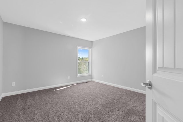 carpeted spare room with baseboards