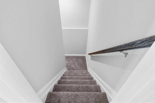 stairway featuring carpet and baseboards