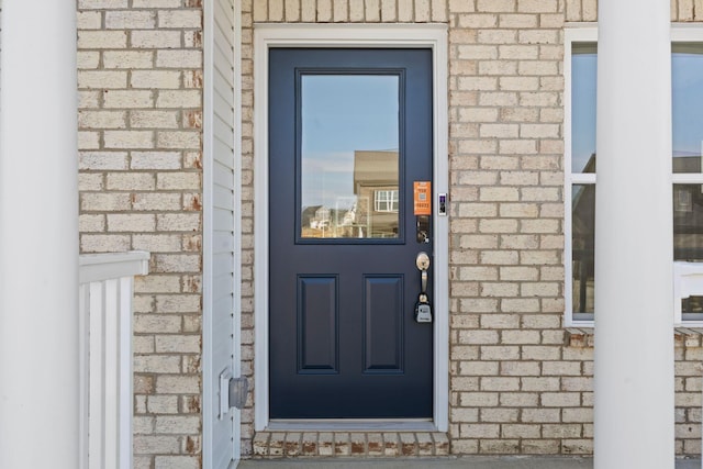 property entrance featuring brick siding