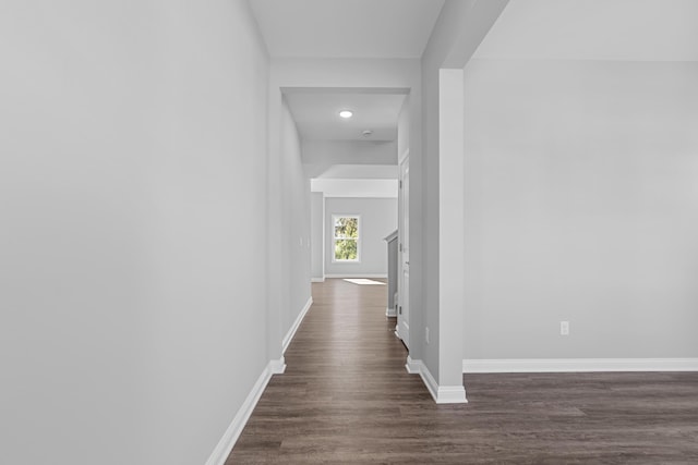 corridor featuring dark wood-style floors and baseboards